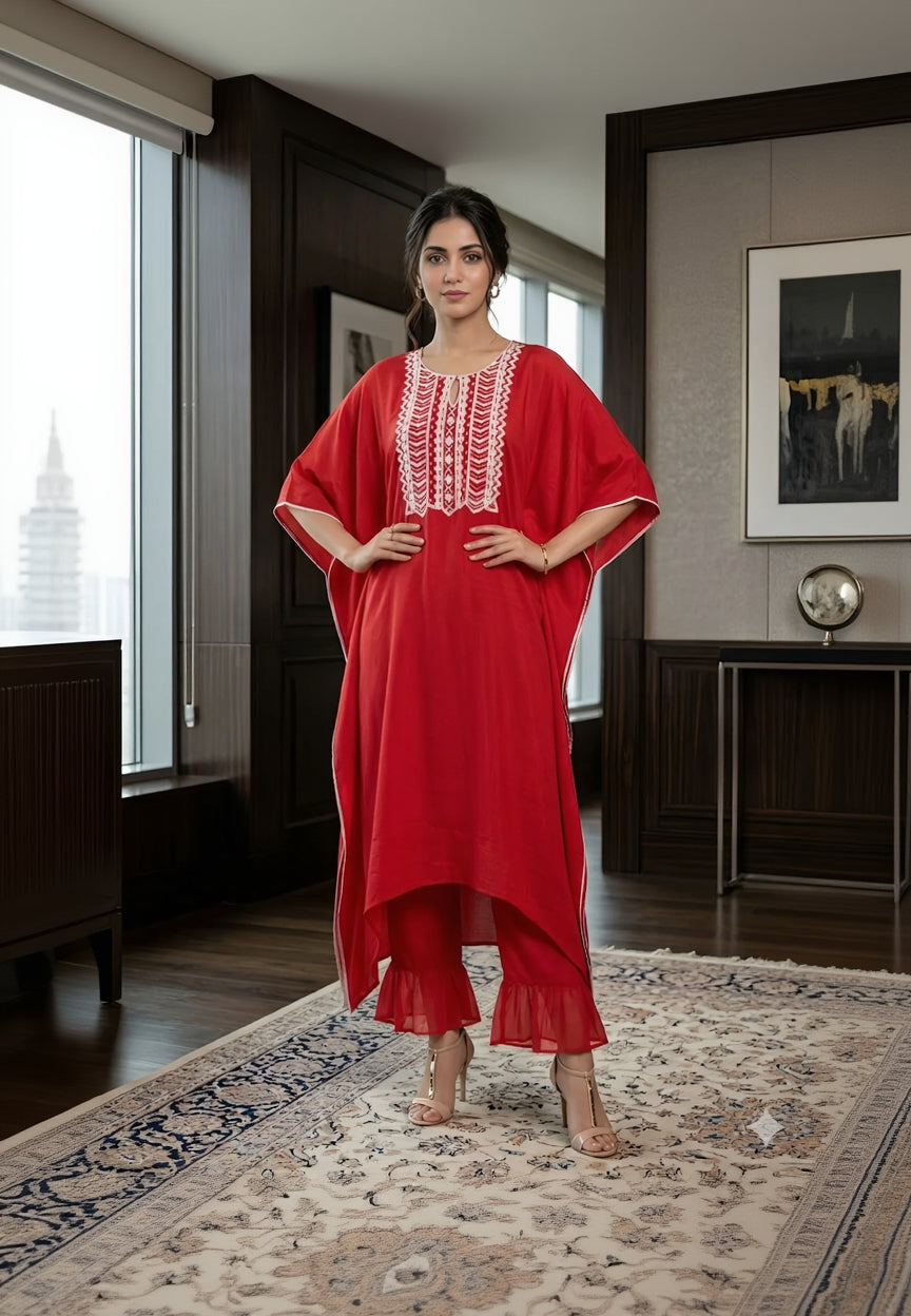 Woman wearing a red dress with white embroidery in an indoor setting