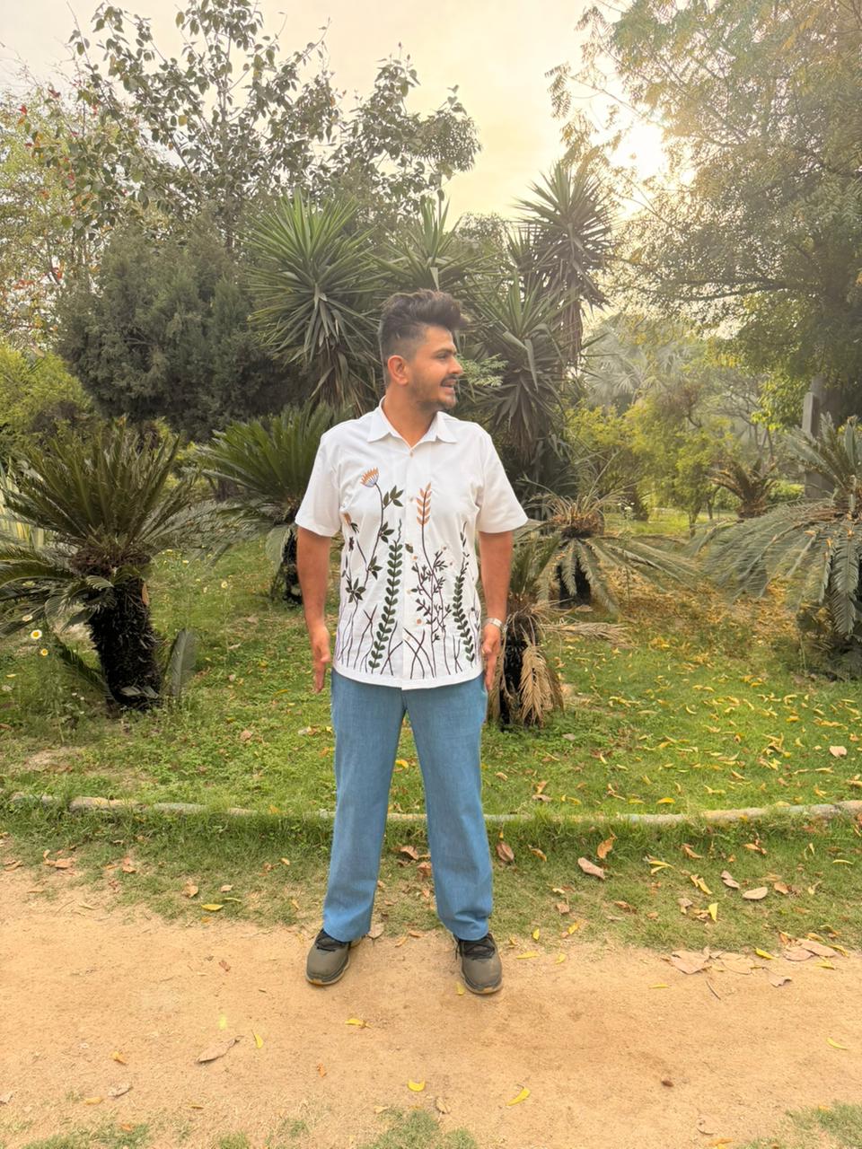 Man standing in a garden with trees and plants in the background