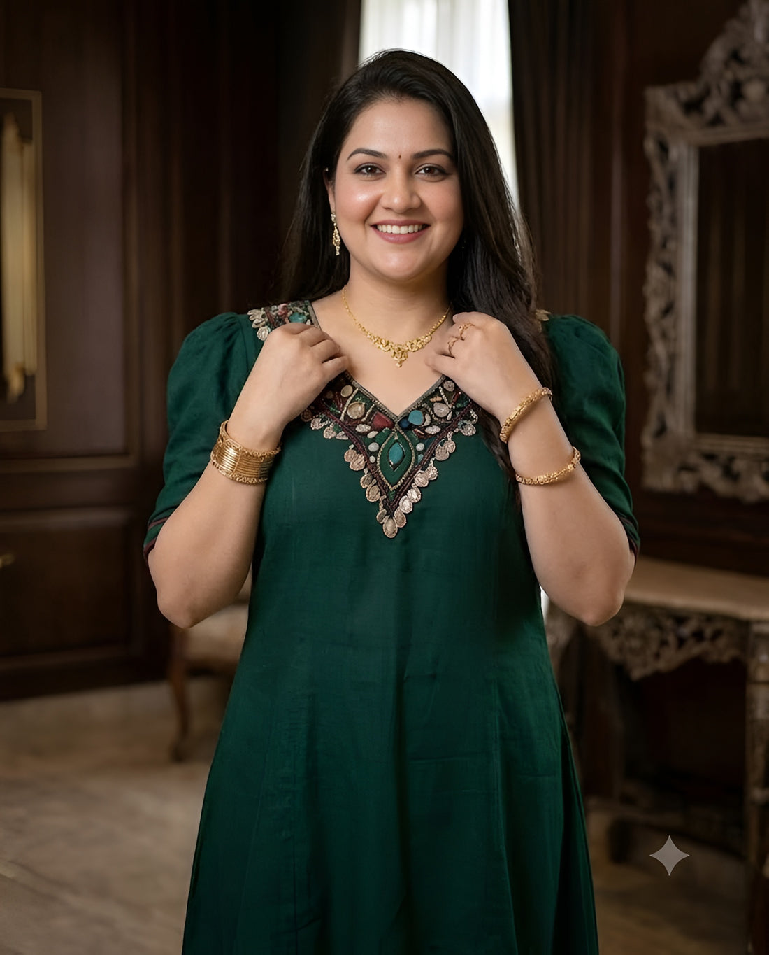 A woman modeling a dark green high-low kurta set with matching pants in an elegant, dark wood-paneled room.