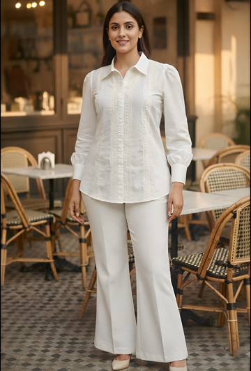 Woman in a white outfit standing in an outdoor cafe setting