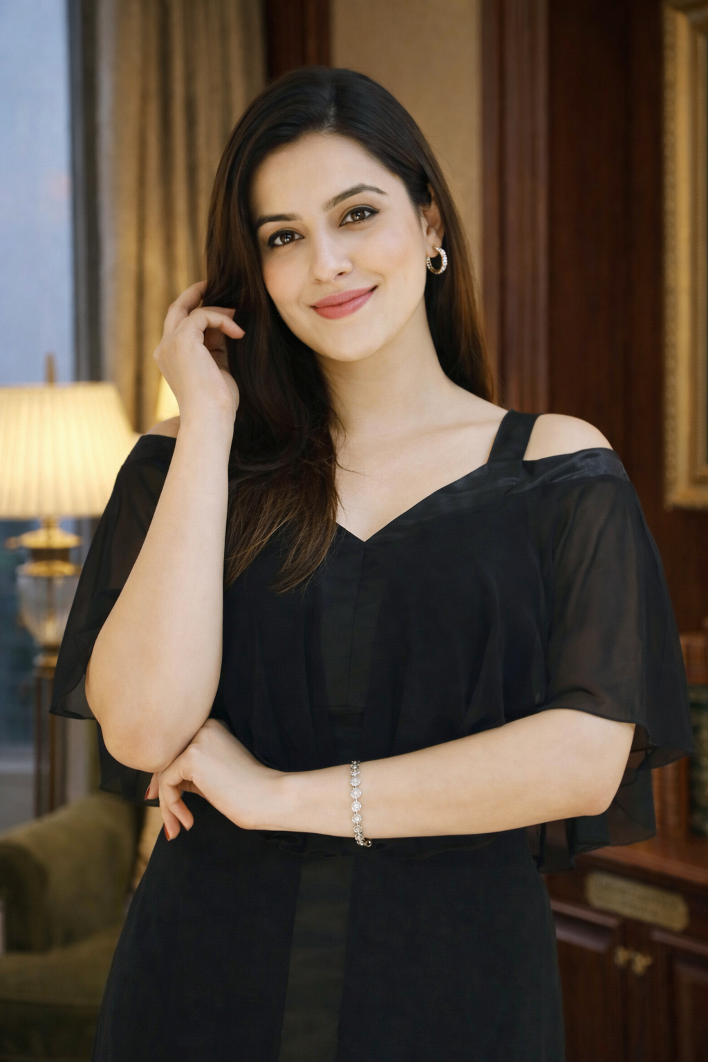Woman in a black dress standing in an elegant room with decor elements.