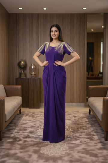 Woman in a purple evening gown with beaded shoulders in an indoor setting