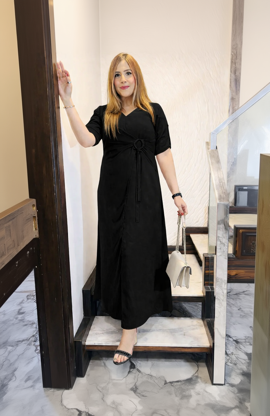 Woman wearing a black dress standing on a staircase.