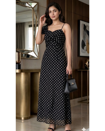 Woman wearing a black polka dot dress in an indoor setting.