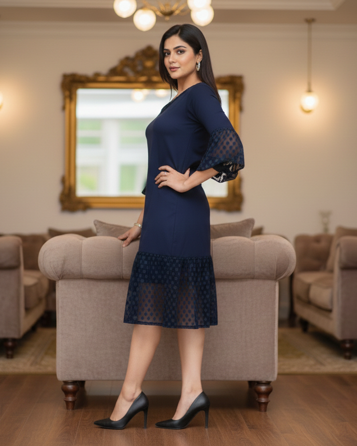 Woman in a navy blue dress standing in a living room.