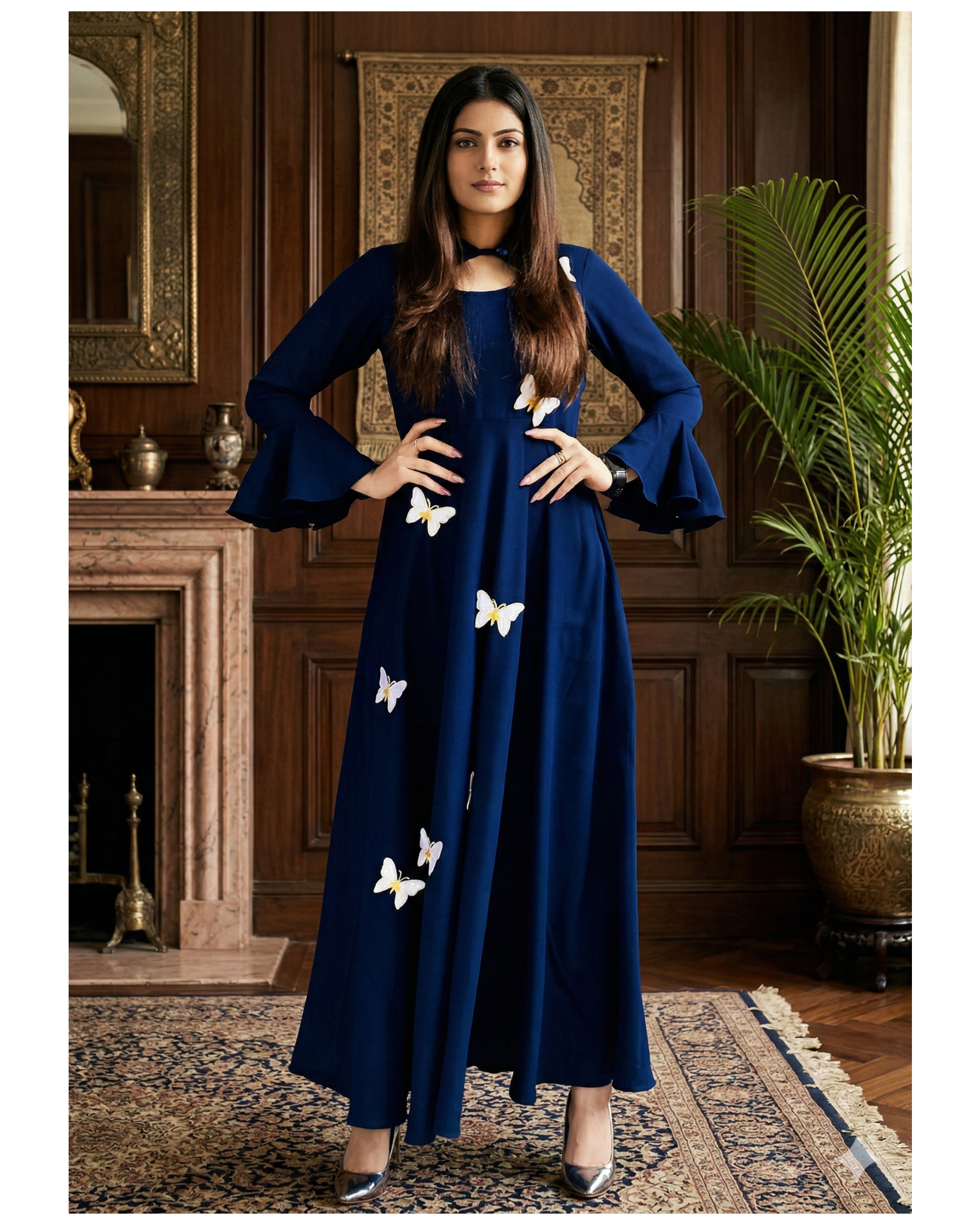 Woman wearing a blue dress with white butterfly patterns in an elegant room.