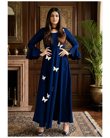 Woman wearing a blue dress with white butterfly patterns in an elegant room.