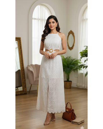Woman in a white lace dress standing in a well-lit room with large windows and decorative elements.