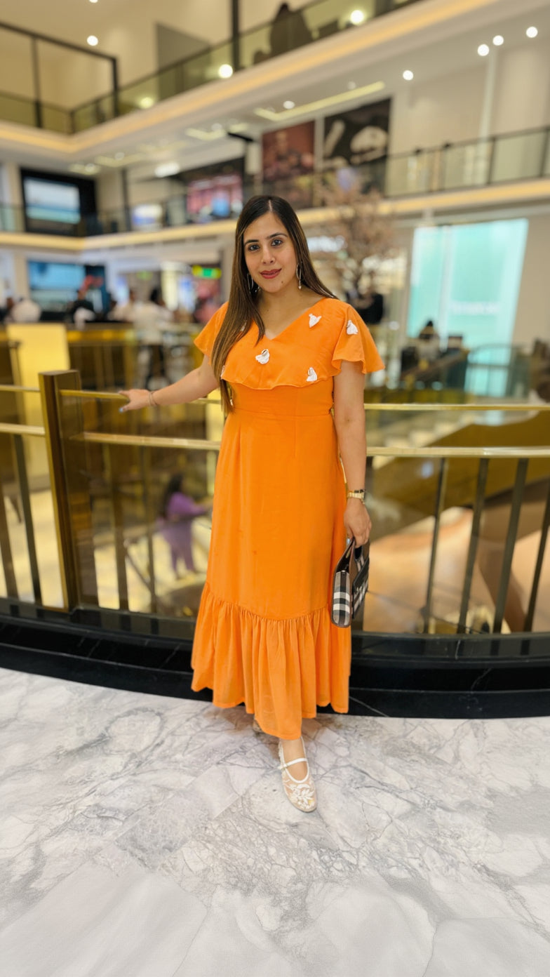 Woman in an orange dress standing in a mall