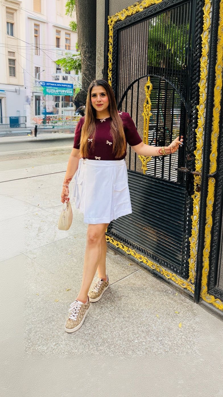 Woman standing in front of a decorative black gate on a city street.