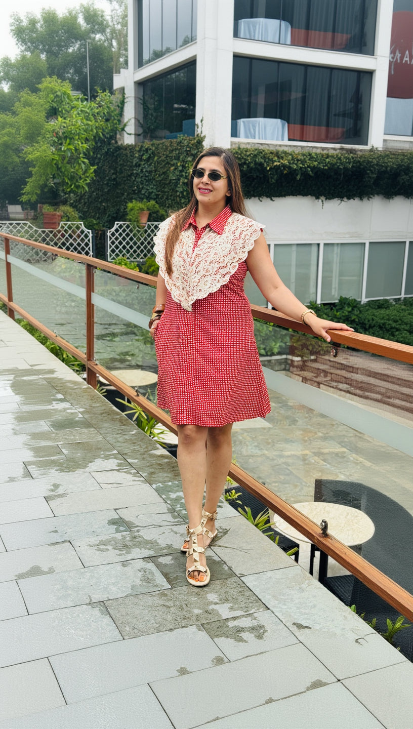 Woman in a red dress with lace details walking outdoors.