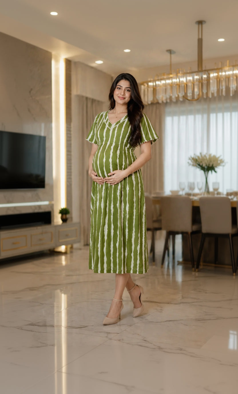 Woman in a green and white striped dress standing in a modern living room.