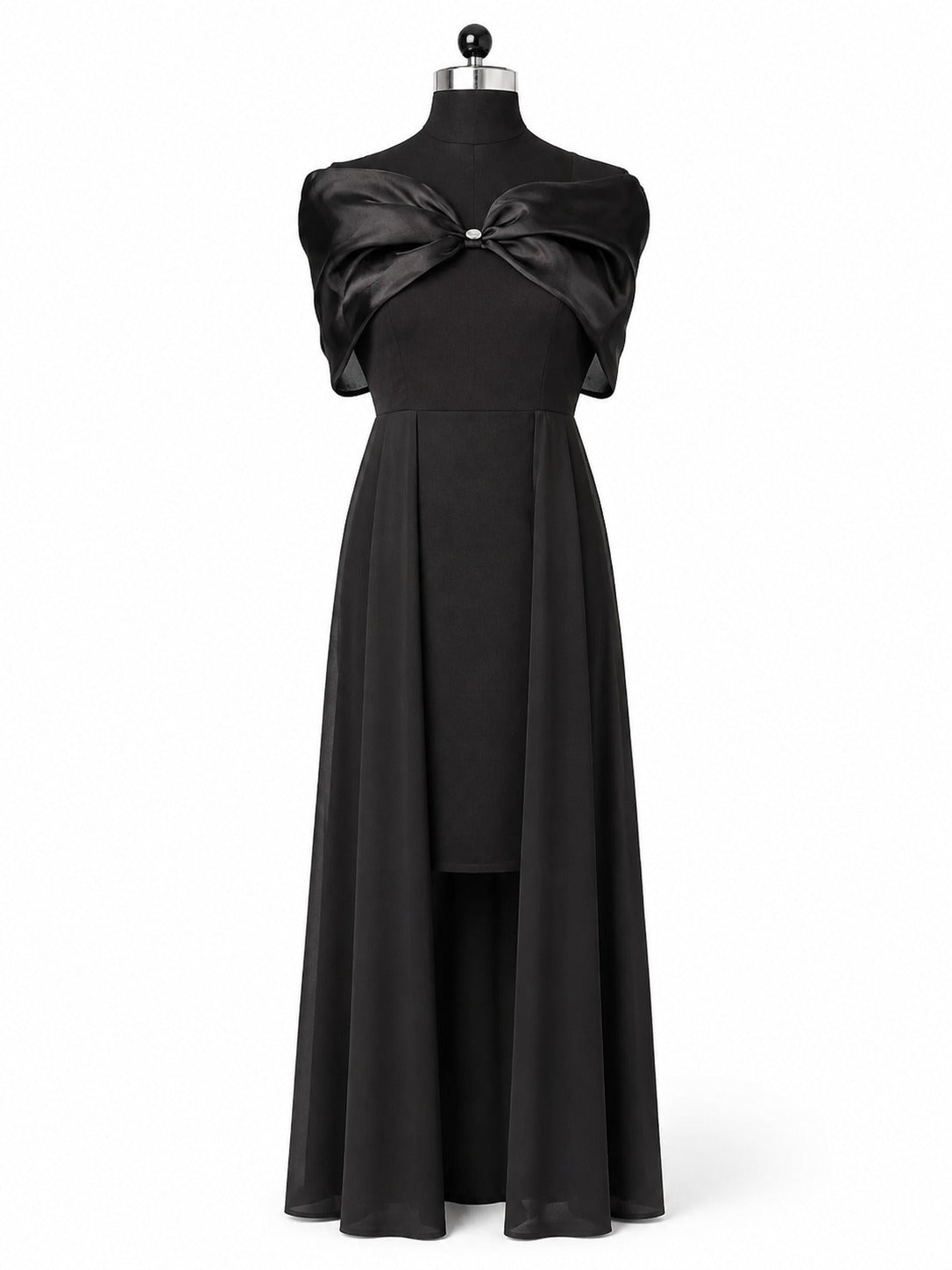 A floor-length black gown displayed on a mannequin against a plain white studio background. The dress has a dramatic oversized bow detail at the bust with a small silver-toned center accent and a flowing skirt.