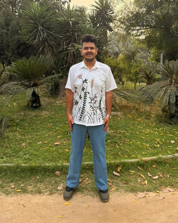 Man standing in a garden with trees and plants in the background