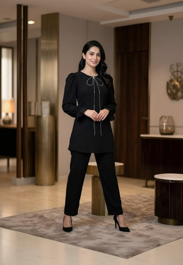 Woman in a black outfit standing in an indoor setting