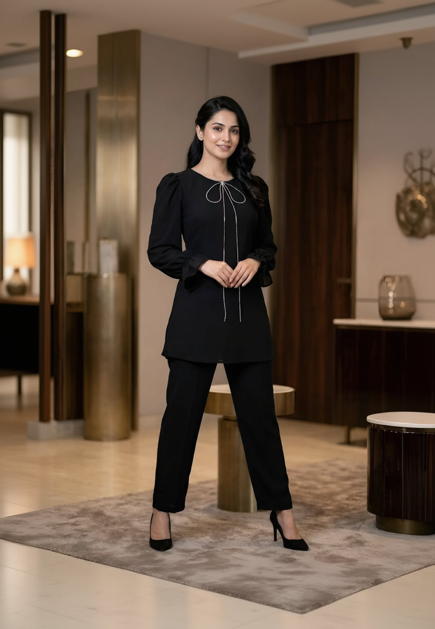 Woman in a black outfit standing in an indoor setting