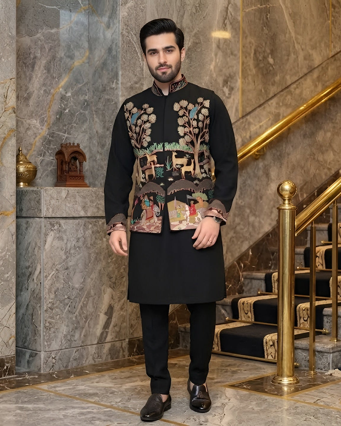 Man in traditional attire standing in a luxurious interior setting with marble walls and gold accents.