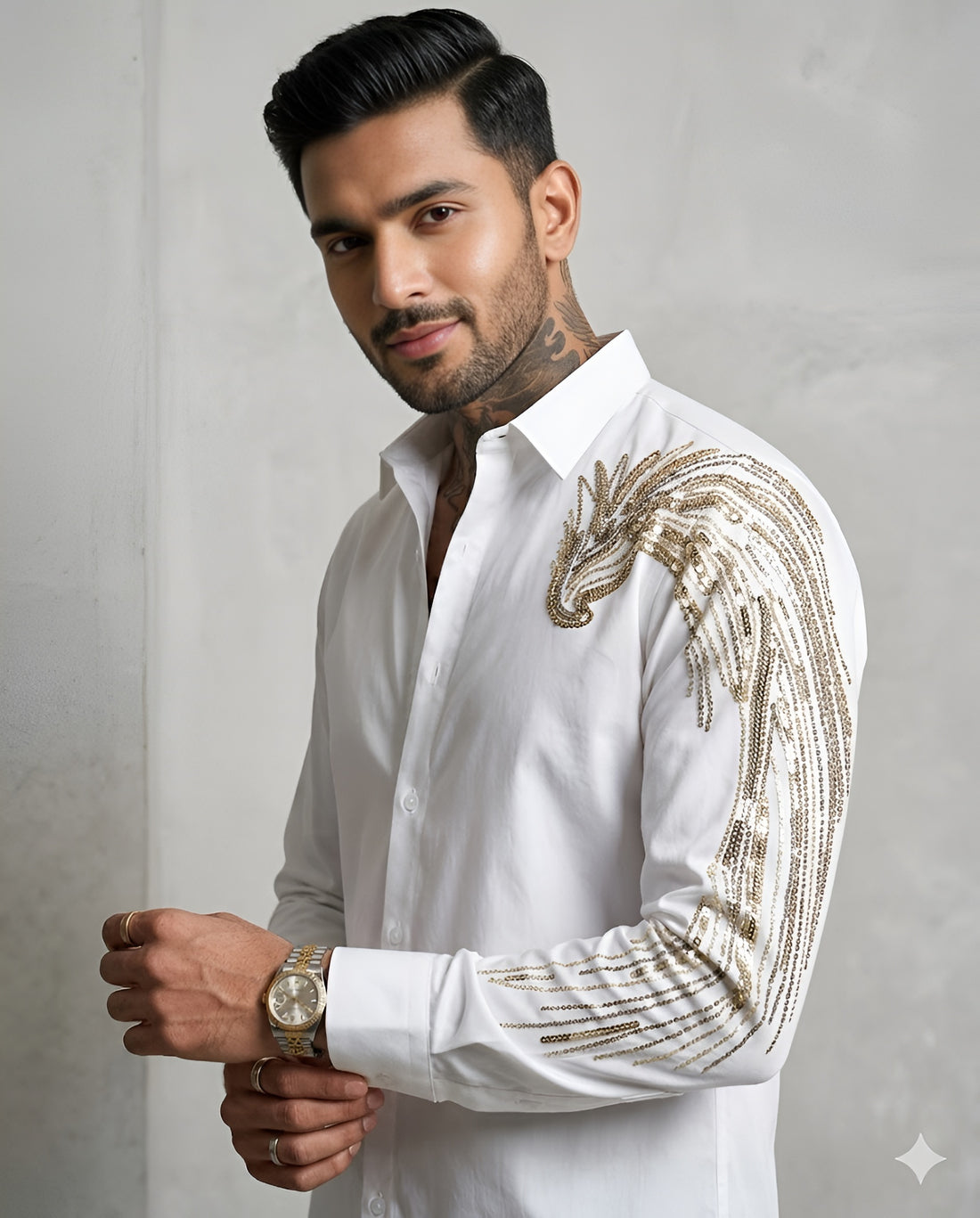 Man wearing a white shirt with gold embroidery on a gray background